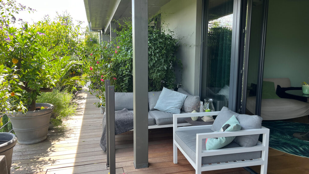 Moderne Balkonterrasse mit Loungemöbeln und üppigen Pflanzen