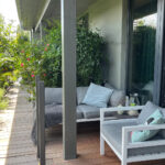 Moderne Balkonterrasse mit Loungemöbeln und üppigen Pflanzen