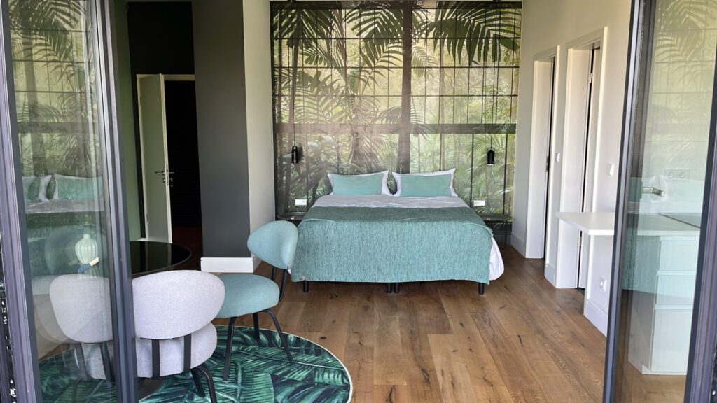 Modernes Schlafzimmer mit tropischer Wandtapete und Holzboden