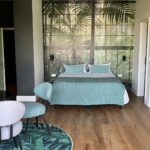 Modernes Schlafzimmer mit tropischer Wandtapete und Holzboden