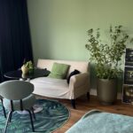 Modernes Wohnzimmer mit grüner Deko und Balkon