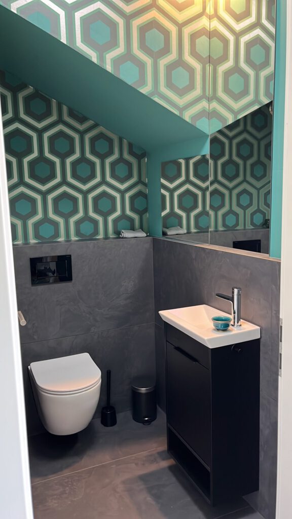 Modernes kleines Badezimmer mit geometrischer Tapete und Wand-WC