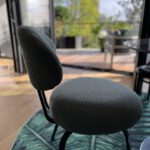 Moderner Polsterstuhl vor offener Terrassentür mit Gartenblick