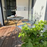 Sonniger Balkon mit Tisch, Stuhl und Pflanzen
