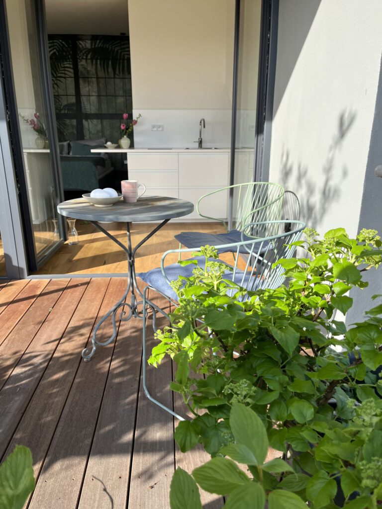 Sonniger Balkon mit Tisch, Stuhl und Pflanzen