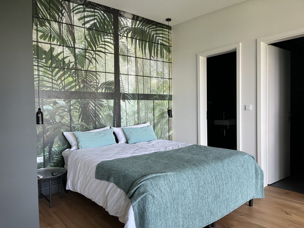 Modernes Schlafzimmer mit Dschungel-Wandbild und Doppelbett