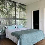 Modernes Schlafzimmer mit Dschungel-Wandbild und Doppelbett