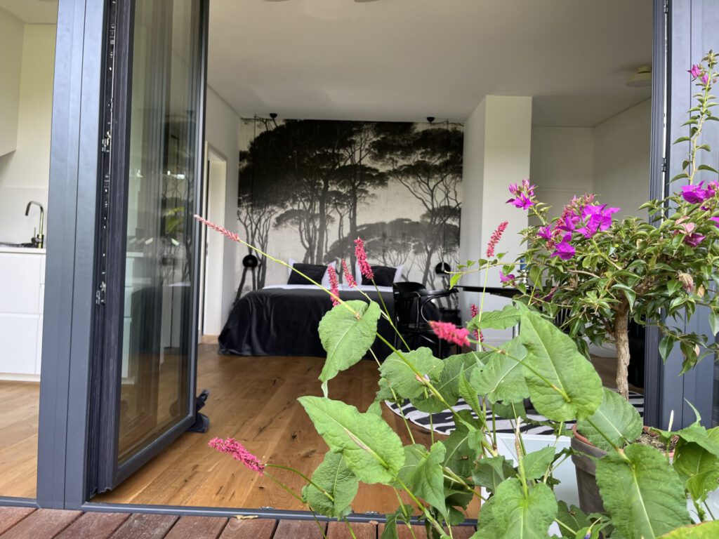 Modernes Schlafzimmer mit Wandbild und Terrassepflanzen