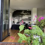Modernes Schlafzimmer mit Wandbild und Terrassepflanzen