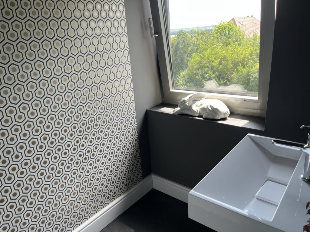 Modernes Badezimmer mit Hasenfigur am Fenster