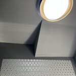 Runde Deckenleuchte über gemusterter Wand mit Fliesen