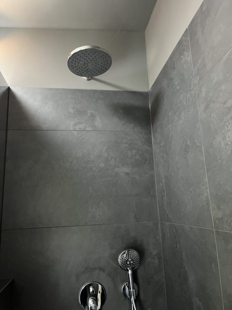 Moderne Regendusche mit grauen Fliesen im Badezimmer