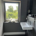 Modernes Badezimmer mit Fenster, Waschbecken und Hasenfigur