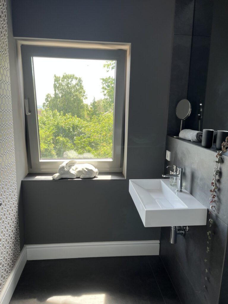 Modernes Badezimmer mit Fenster, Waschbecken und Hasenfigur