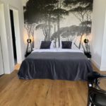Modernes Schlafzimmer mit Waldtapete und Doppelbett