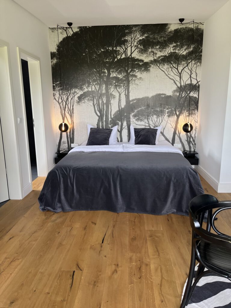 Modernes Schlafzimmer mit Waldtapete und Doppelbett